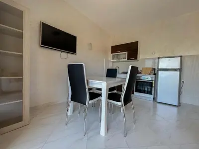 a dining room with a table and chairs in a kitchen at Olive Residence Rezevici in Budva