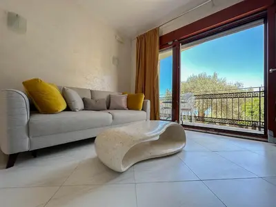 a living room with a couch and a large window at Olive Residence Rezevici in Budva