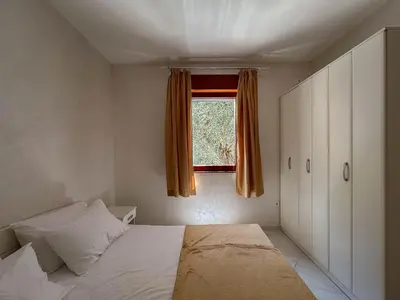 a small bedroom with a bed and a window at Olive Residence Rezevici in Budva