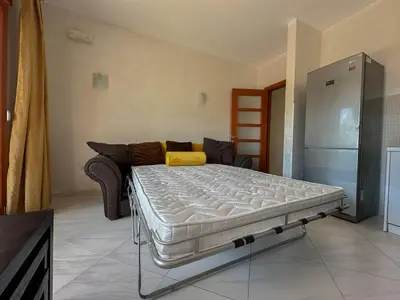 a bed in a living room with a couch at Olive Residence Rezevici in Budva