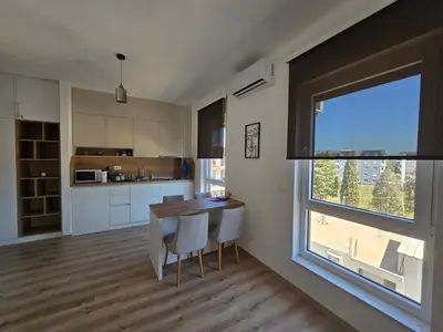 a kitchen with a table and a large window at Porat Apartmani in Ulcinj