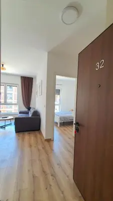a living room with a couch and a wooden floor at Porat Apartmani in Ulcinj
