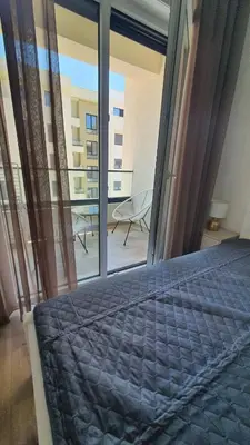a bedroom with a bed and a view of a balcony at Porat Apartmani in Ulcinj