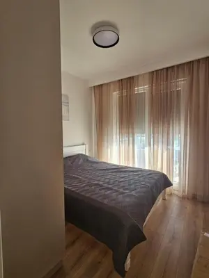 a bedroom with a bed and a large window at Porat Apartmani in Ulcinj