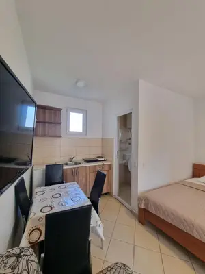 a room with a table and a bed and a kitchen at Apartman-Studio Matanović- Save Kovačevića in Sutomore