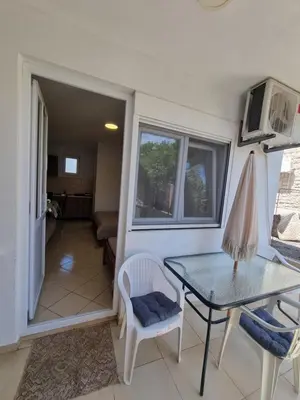 a living room with a table and chairs and a window at Apartman-Studio Matanović- Save Kovačevića in Sutomore