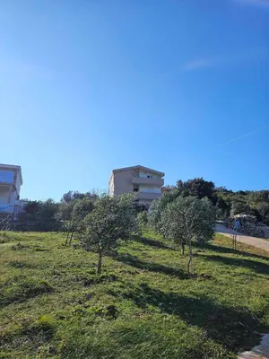 a field with trees and a building in the background at Plavi Horizont in Utjeha