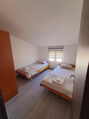 a room with two beds and a window at Plavi Horizont in Utjeha