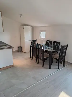 a dining room with a black table and chairs at Plavi Horizont in Utjeha