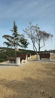 a park with two benches and two trees at Plavi Horizont in Utjeha