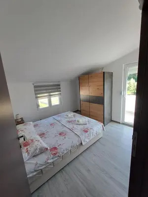 a bedroom with a large bed and a large window at Plavi Horizont in Utjeha