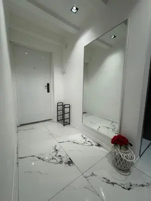 a room with a mirror and a vase with a flower at Matija Urban Suits- Downtown in Podgorica