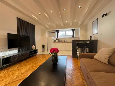 a living room with a couch and a vase of flowers at Matija Urban Suits- Downtown in Podgorica