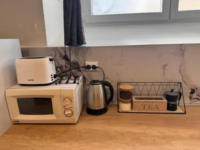 a kitchen counter with a toaster and a microwave at Matija Urban Suits- Downtown in Podgorica