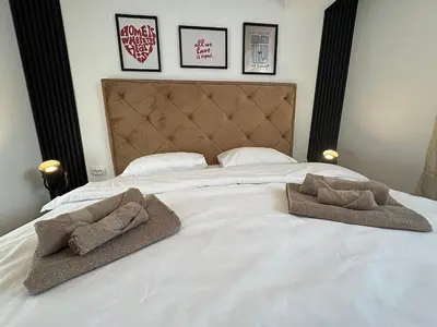 a bed with two towels and two pillows on it at Matija Urban Suits- Downtown in Podgorica