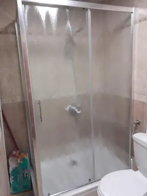 a shower with a glass door next to a toilet at Sea & Mountain View Apartment in Budva