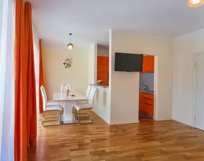 a living room with a table and a kitchen at Sea View Apartments MonteBook in Becici