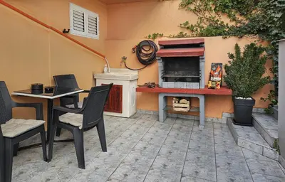 a patio with a table and chairs and a fireplace at Holiday House Kotor in Kotor