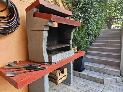 a outdoor brick oven with tools on a wall at Holiday House Kotor in Kotor