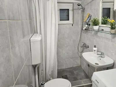 a small bathroom with a toilet and a sink at Holiday House Kotor in Kotor
