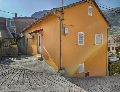 a yellow building with a door and windows at Holiday House Kotor in Kotor