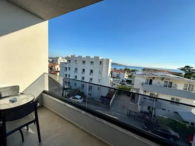 a balcony with a table and a view of a city at Apartmani Kojić 2 in Bar, Susanj