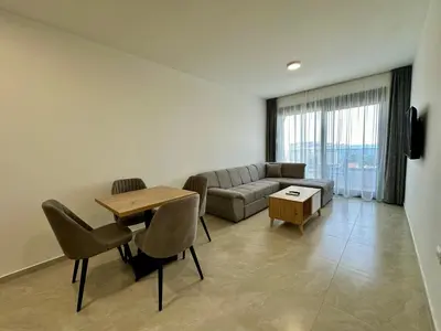 a living room with a couch and a table and chairs at Apartmani Kojić 2 in Bar, Susanj