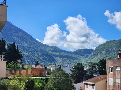 a view of a town with mountains in the background at Megy Apartment with parking and sea view in Kotor