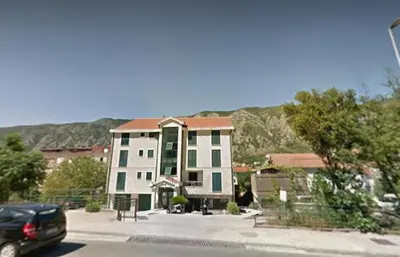 a car is parked in front of a building at Megy Apartment with parking and sea view in Kotor