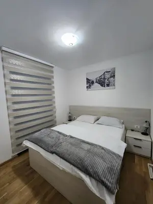 a bedroom with a large bed and a window at Megy Apartment with parking and sea view in Kotor