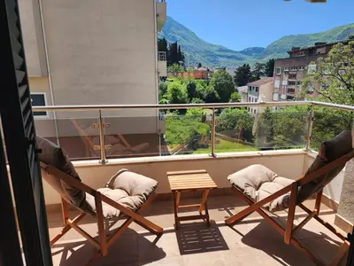 two chairs and a table on a balcony with a view at Megy Apartment with parking and sea view in Kotor