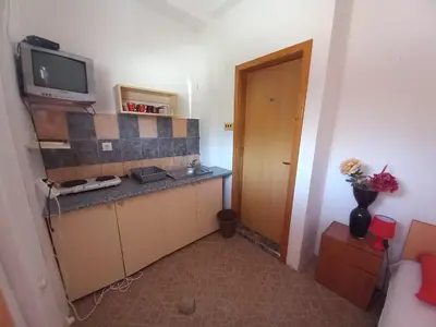 a room with a kitchen with a tv on a counter at Apartmani Todorović in Bar