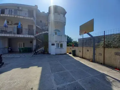 a building with a tower in front of a building at Apartmani Todorović in Bar