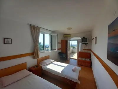 a hotel room with two beds and a window at Apartmani Todorović in Bar