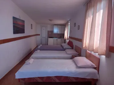 a row of beds in a room with windows at Apartmani Todorović in Bar