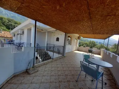 a balcony of a house with a table and chairs at Apartmani Todorović in Bar