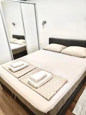 a bedroom with a bed with mirrors and towels on it at Mira Apartment in Dobra Voda