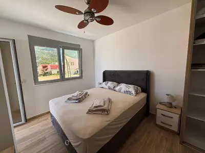 a bedroom with a bed with a ceiling fan at Hana Apartments in Dobra Voda