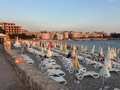 a group of chairs and umbrellas on a beach at Hana Apartments in Dobra Voda