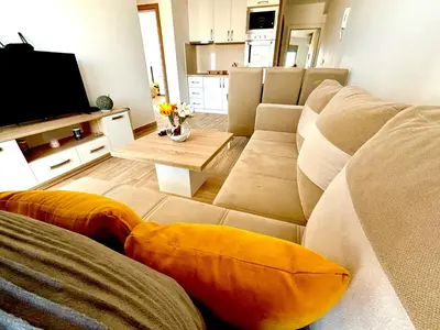 a living room with a couch and a television at Hana Apartments in Dobra Voda