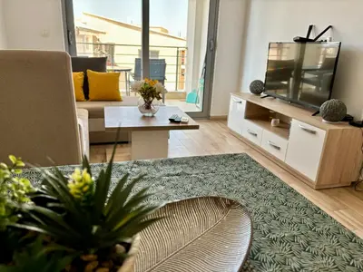 a living room with a couch and a tv at Hana Apartments in Dobra Voda
