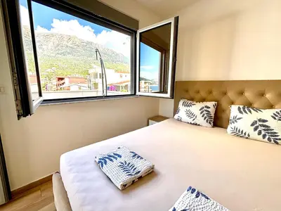 a bedroom with a bed and a large window at Hana Apartments in Dobra Voda