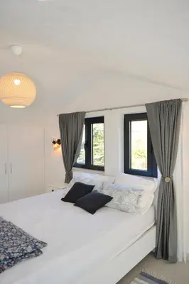 a bedroom with a large white bed with windows at Green Ranch Stara Maslina in Kotor