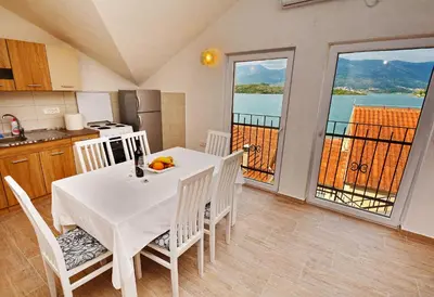 a kitchen and dining room with a table and chairs at Apartments Bella di Boka in Tivat