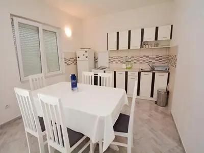 a kitchen with a white table and white chairs at Apartments Bella di Boka in Tivat