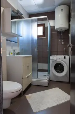 a bathroom with a toilet and a washing machine at Apartment Taurus in Petrovac na Moru