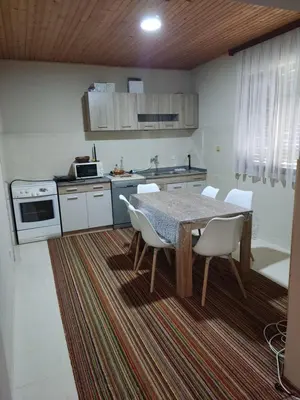 a kitchen with a table and white chairs in a room at Tangerine terrace in Ulcinj