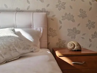 a bedroom with a bed and a wooden nightstand with a nautilus at Diva Residence in Budva