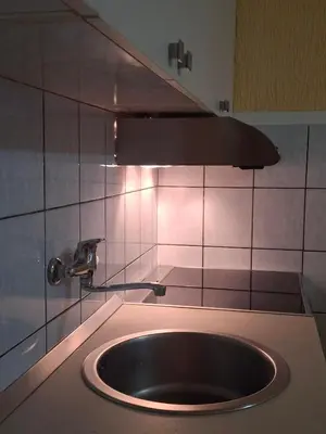a sink in a kitchen with a light above it at Apartments D&D Sutomore in Sutomore