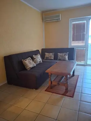 a blue couch in a living room with a table at Apartments D&D Sutomore in Sutomore